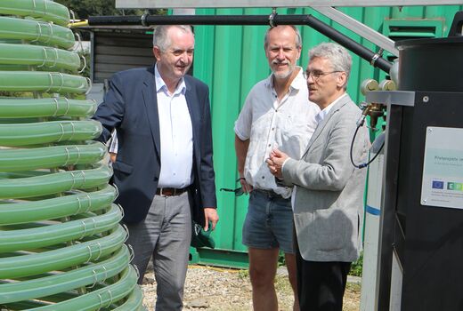 Minister Schmidt unterhält sich mit Prof. Großmann über die Algenproduktion im Photobioreaktor der Firma GICON.