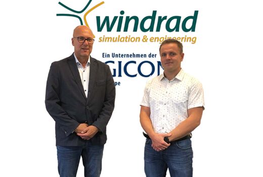 Two men stand next to each other and look directly into the camera