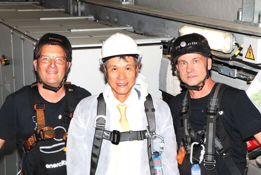 Three men with climbing harnesses on wind turbine